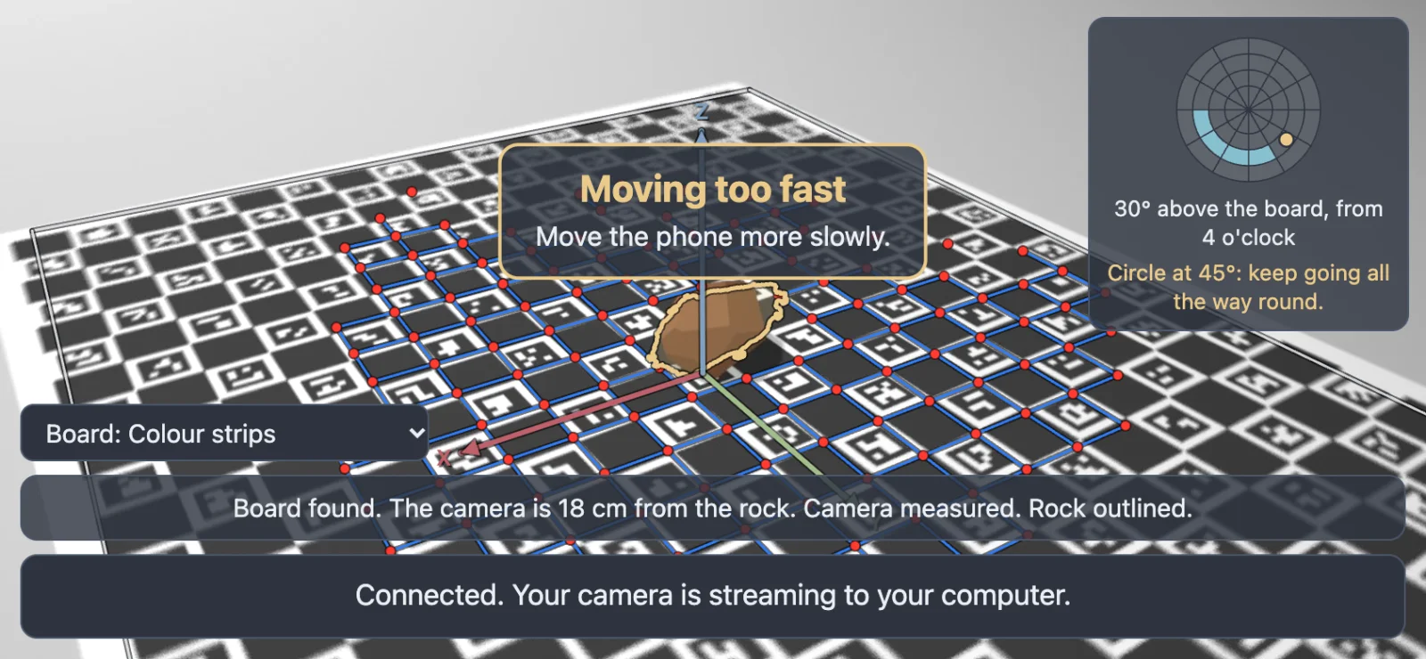 The phone's screen with a motion-blurred picture of the board and a box in the middle reading Moving too fast, Move the phone more slowly.